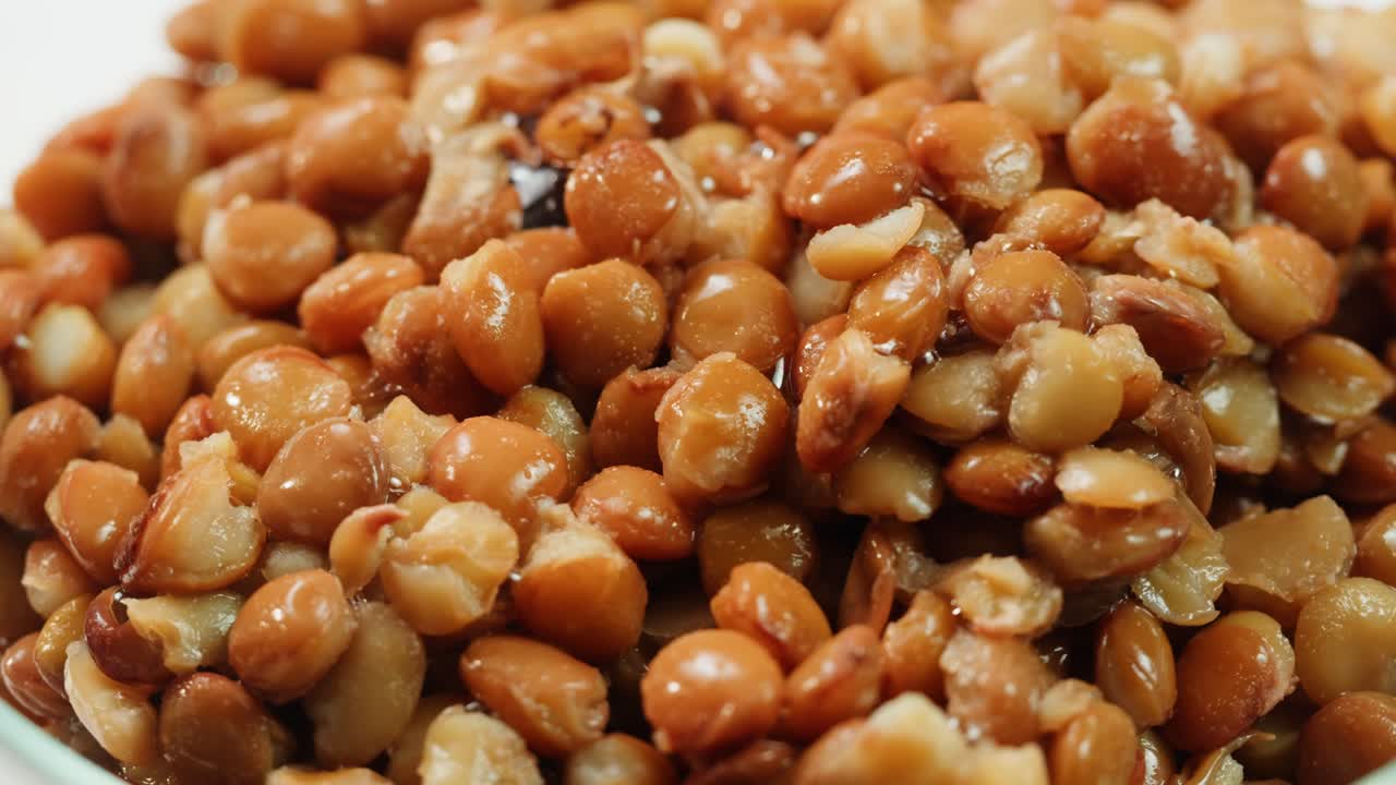 Lentils macro, Open metal can with preserved steamed brown lentils close up isolated on white background