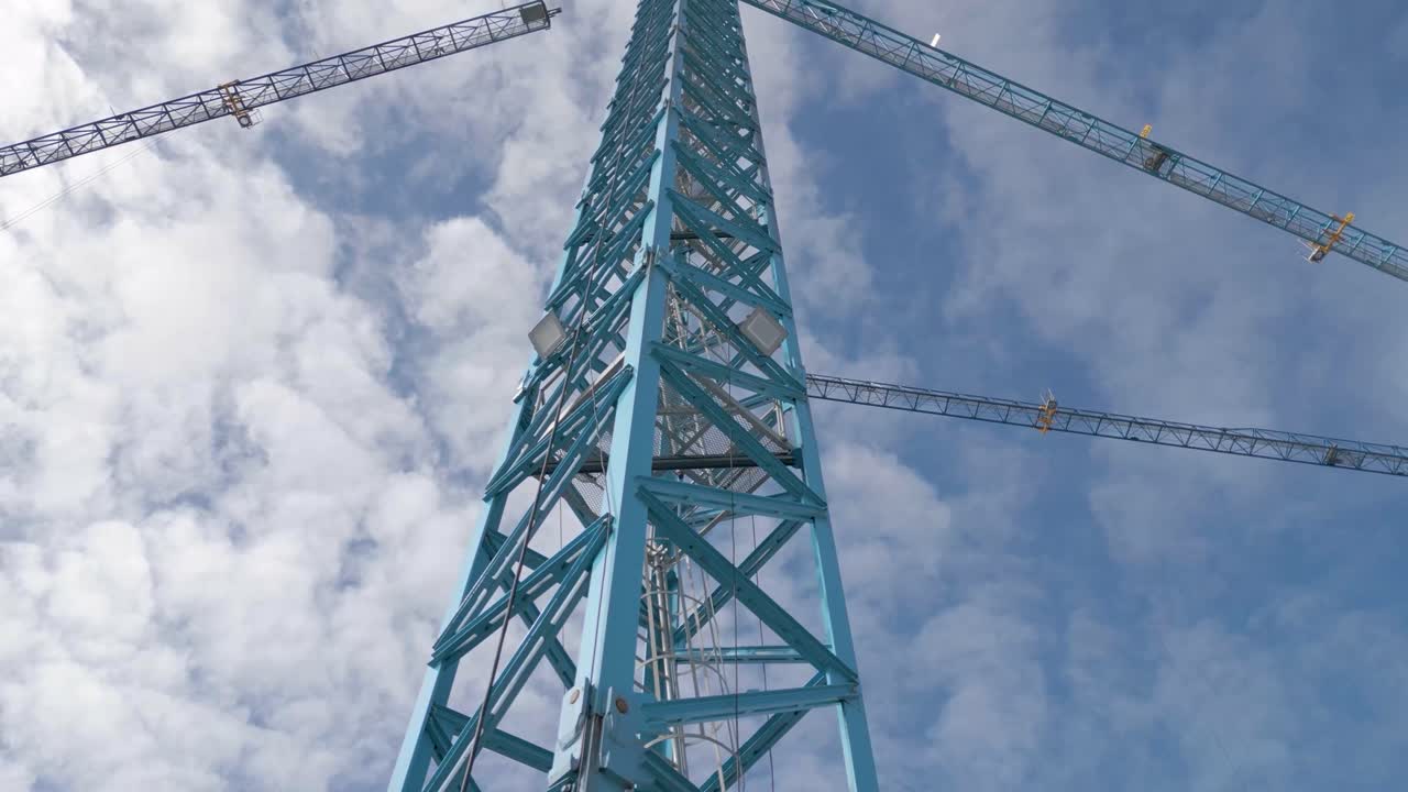 columna metálica de grúa de construcción con escaleras y cielo nublado azul en el fondo