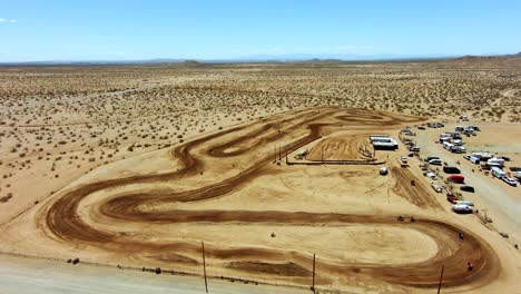 vista aérea de una pista todoterreno durante una carrera de motos en el desierto - cámara lenta