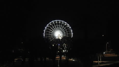 Vista-Nocturna-Del-Parque-De-Atracciones-Por-La-Noche,-Gran-Noria-Con-Iluminación-Azul-Festiva-Contra-El-Cielo-Nocturno,-Famosa-Atracción-Turística,-Ciudad-De-Agadir-En-Marruecos