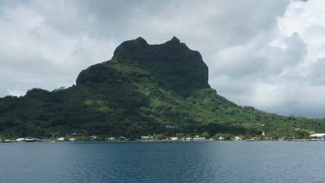 view of a mountain from a moving boat in a tropical pacific island in bora bora, french, polynesia.