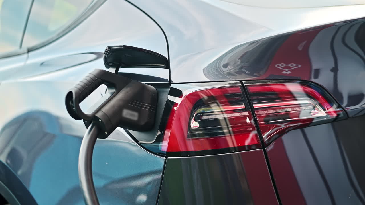 Bir şarj istasyonunda elektrikli bir arabaya takılı şarj cihazının yakın çekim görüntüsü