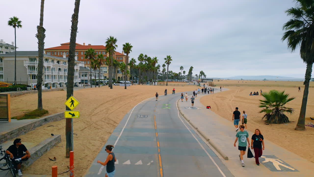 Los Angeles, USA, 29 August 2025: People walk, run, ride and roller-skate by the road at Santa Monica beach. Sport life of Americans in LA, California, USA. Aerial view