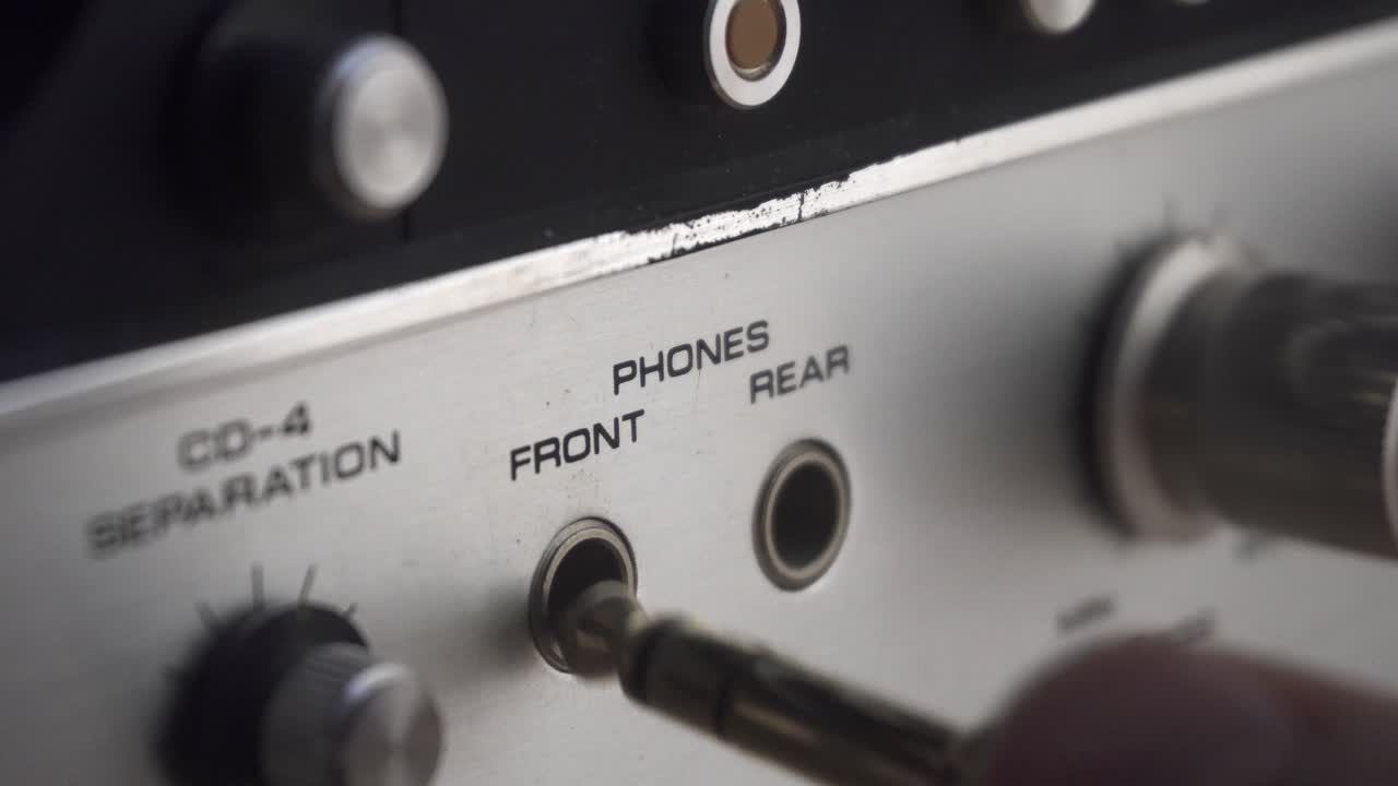 enchufar y desenchufar un conector para auriculares, en un amplificador antiguo y retro
