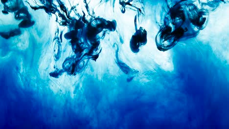 4k footage of green and blue colorful ink drops in water, isolated abstract background. pouring ink in water. underwater paint mix. slow psychedelic dye swirls, colored smoke explosion. splashing, floating liquid