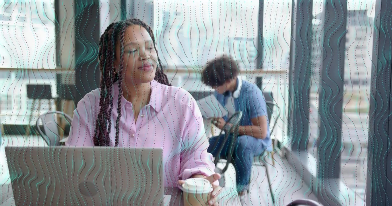 Tech professional typing on laptop and pausing for coffee aroma while colleague studying tablet