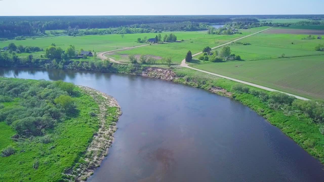vista aérea de un río venta en un día soleado de verano, exuberantes árboles y prados verdes, hermoso paisaje rural, tiro de muñeca de drones de gran angular moviéndose a la izquierda