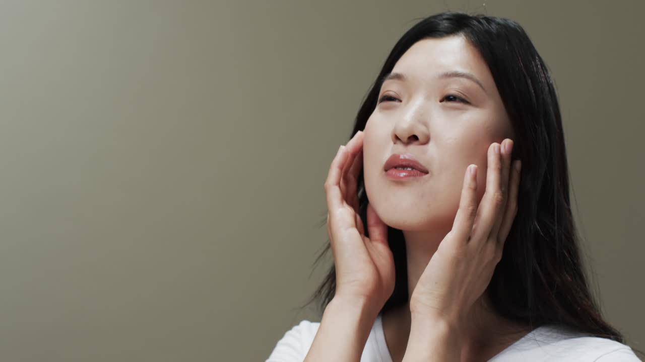 검은 머리카락과 메이크업으로 얼굴을 만지는 아시아 여성 복사 공간, 느린 모션