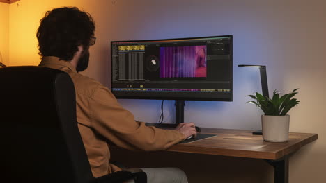 time lapse shot of young bearded man editing video on a minimalist desk setup