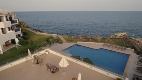 Aerial-Dolly-Back-Shot-Over-Swimming-Pool-Overlooking-Sea-At-Luxury-Hotel-In-Mallorca