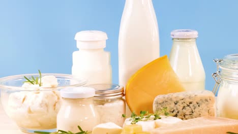 A variety of dairy products including milk, cheese, and yogurt displayed against a blue backdrop.