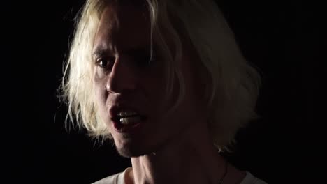 Close-up-of-blond-long-haired-man-hopelessness-screaming-in-angriness