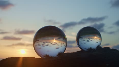 view of sunset in side two crystal balls on a timber.