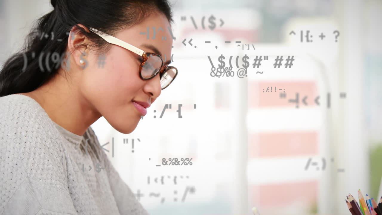 Animation of special symbols over asian female student writing notework at desk in classroom