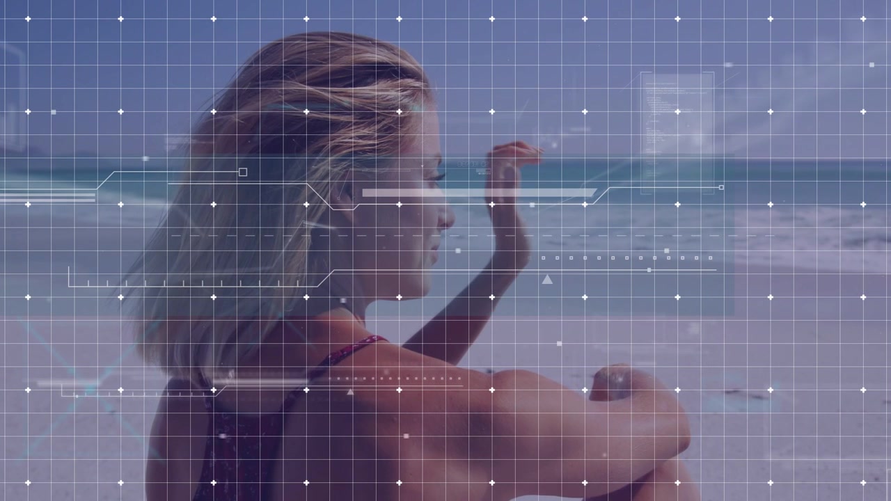 Kvinde sidder på strand og observerer HUD-gitter, der dukker op, og laver små gestus til en tech-demo.
