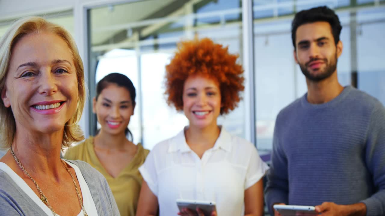 Front-left woman posing with team holding devices, creating growing social counts for marketing