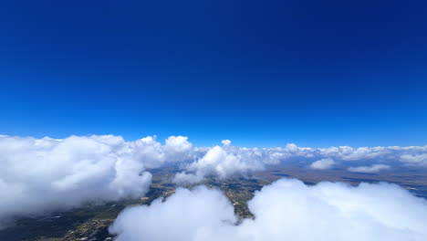 lovely fluffy clouds hanging in the sky. fpv drone turns in the cloudscape revealing the view on the city view below.