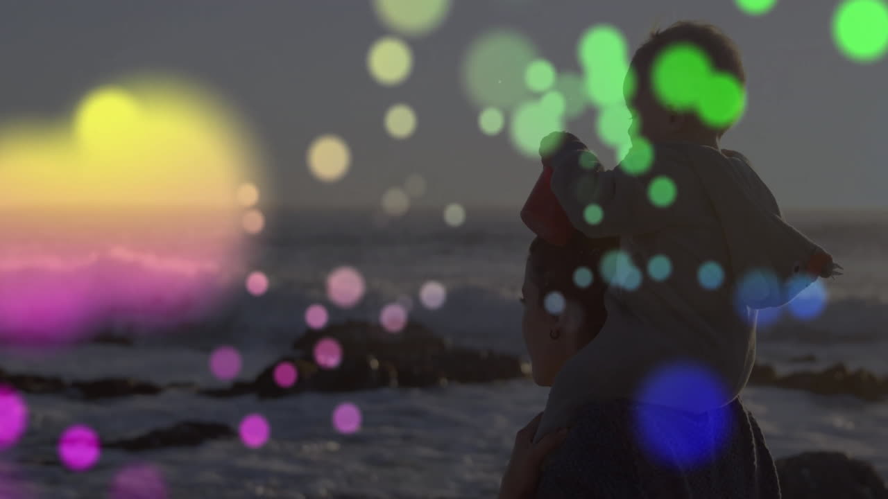 At beach, child sitting on adult's shoulders with colorful animation overlay