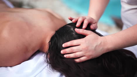 junge sportliche frau mit schwarzer haut in zeitlupe, die eine entspannende tiefengewebemassage von einer professionellen therapeutin im luxus-spa erhält