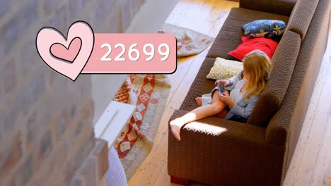 Woman-sitting-on-a-couch-typing-on-her-phone-4k