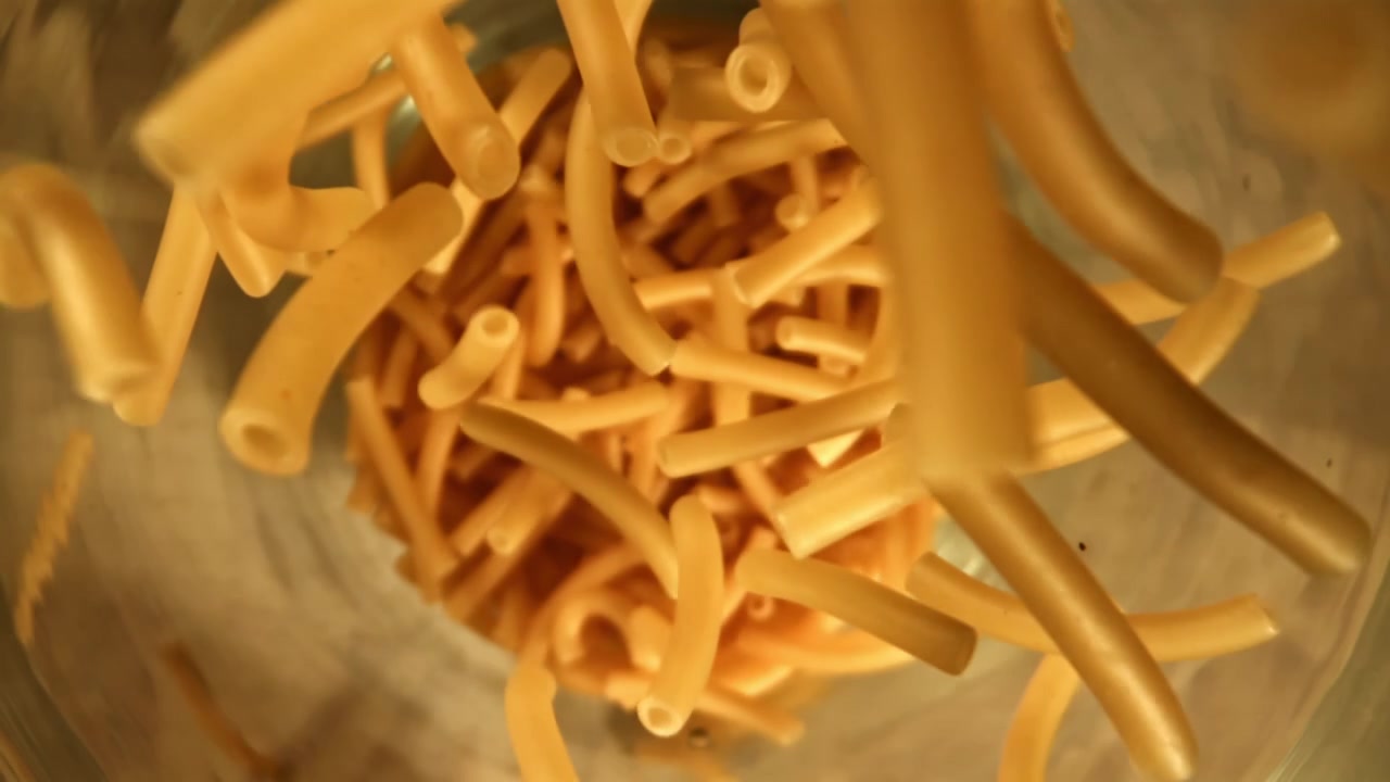 Maccheroni crudi che cadono in una pentola al rallentatore