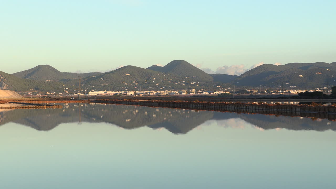 왼쪽 판 드 라스 살리나스 데 이비자(pan de las salinas de ibiza)에는 새벽빛이 물에 반사되어 있고, 배경에는 스페인 이비자 채석장이 있습니다.