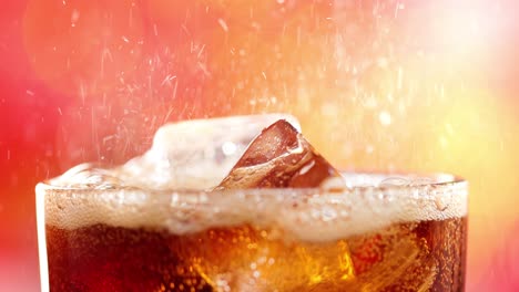 un vaso de cola. cola helada con burbujas salpicando cámara lenta en una luz borrosa, fondo borroso.