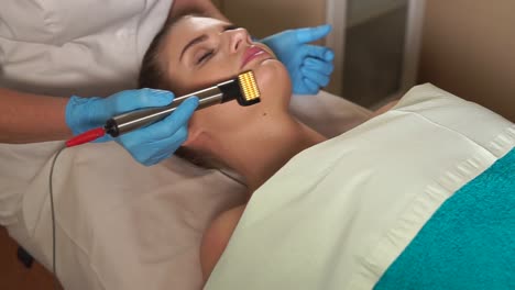 woman receiving facial roller treatment