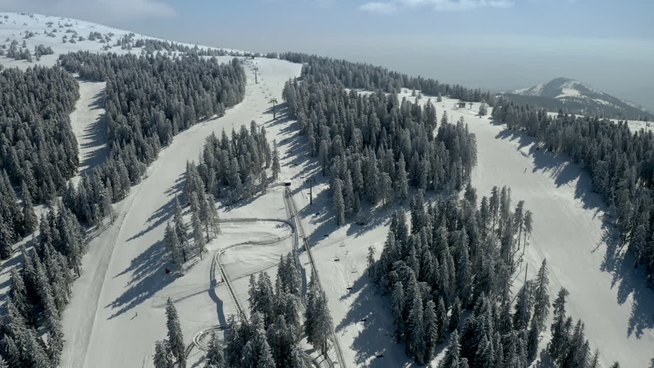 Aerial View of a Snow-Covered Ski Resort with Pine Trees and Slopes