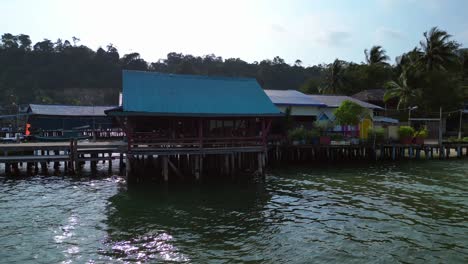 colorful bungalows rising on a tropical beach in koh rong island, cambodia. smooth aerial view flight dolly left drone