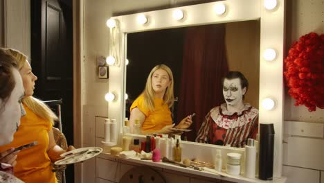 makeup artist applying clown makeup for a halloween event