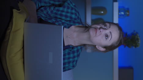 Vertical-video-of-Woman-getting-tired-while-using-computer-at-night.