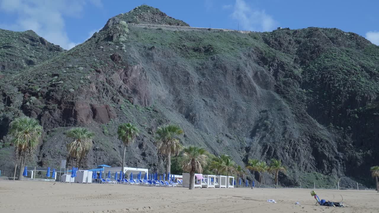 Paisaje de playa tropical con palmeras y montañas verdes