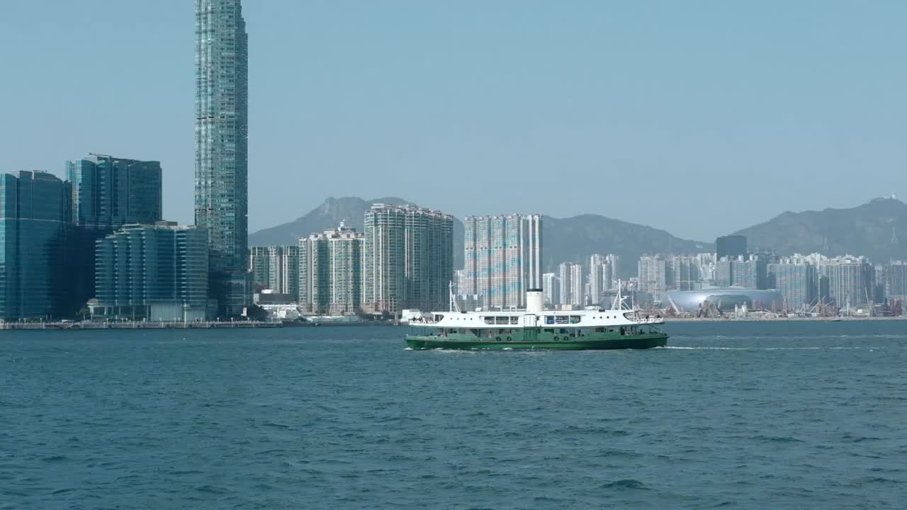 Scenic view of Hong Kong harbor with a ferry boat crossing. Captures the energy of city life, marine transportation, and iconic skyline. Ideal for travel, lifestyle, and urban documentary projects.