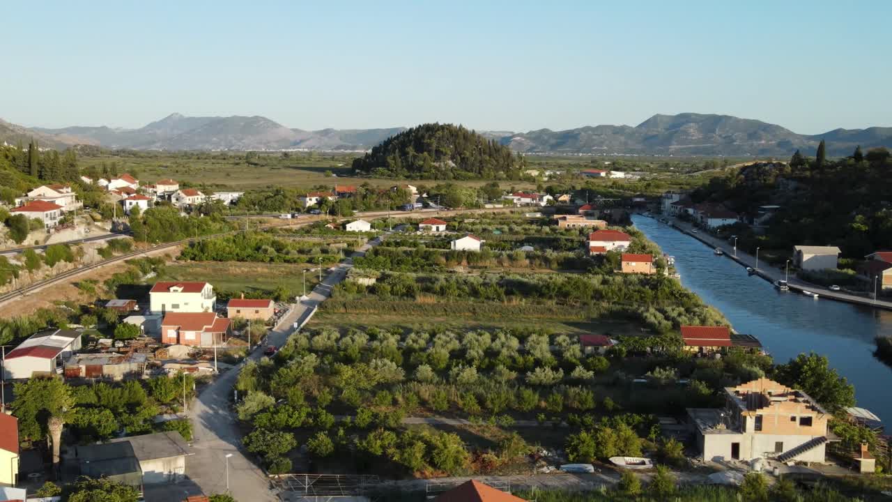 Slide over spectacular landscape in summer evening light with village and river meandering among hills