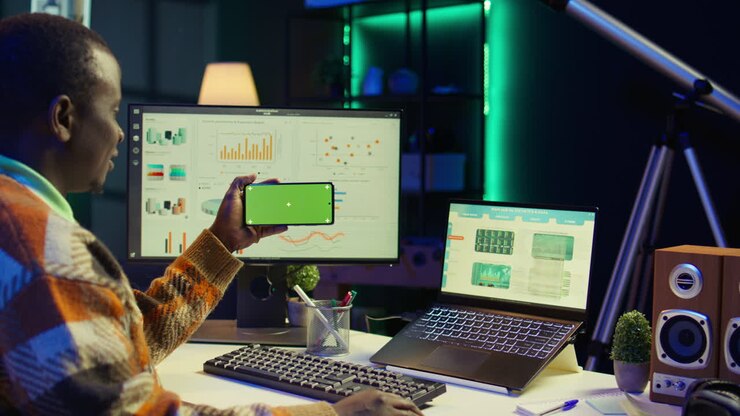 Man working with green screen on phone at office