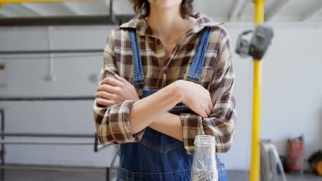 Female-welder-standing-with-arms-crossed-in-workshop-4k