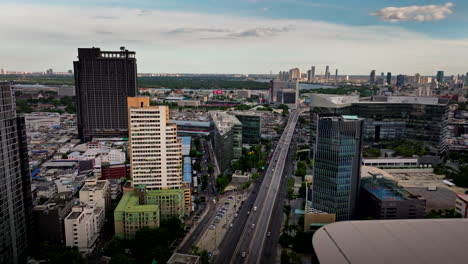 drone dolly view over bangkok cityscape and main road with traffic, thailand