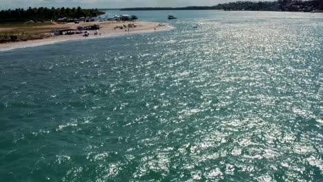 Incline-Hacia-Arriba-La-Muñeca-En-Una-Toma-Aérea-Sobrevolando-La-Turística-Playa-Tropical-De-Restinga-Donde-El-Gran-Río-Curimataú-Se-Encuentra-Con-El-Mar-Cerca-De-Barra-Do-Cunhaú-En-Rio-Grande-Do-Norte,-Brasil-En-Un-Día-De-Verano