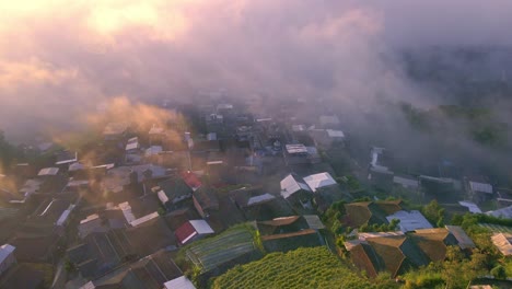 Aerial-view-of-countryside-on-the-slope-of-mountain-shrouded-by-mist