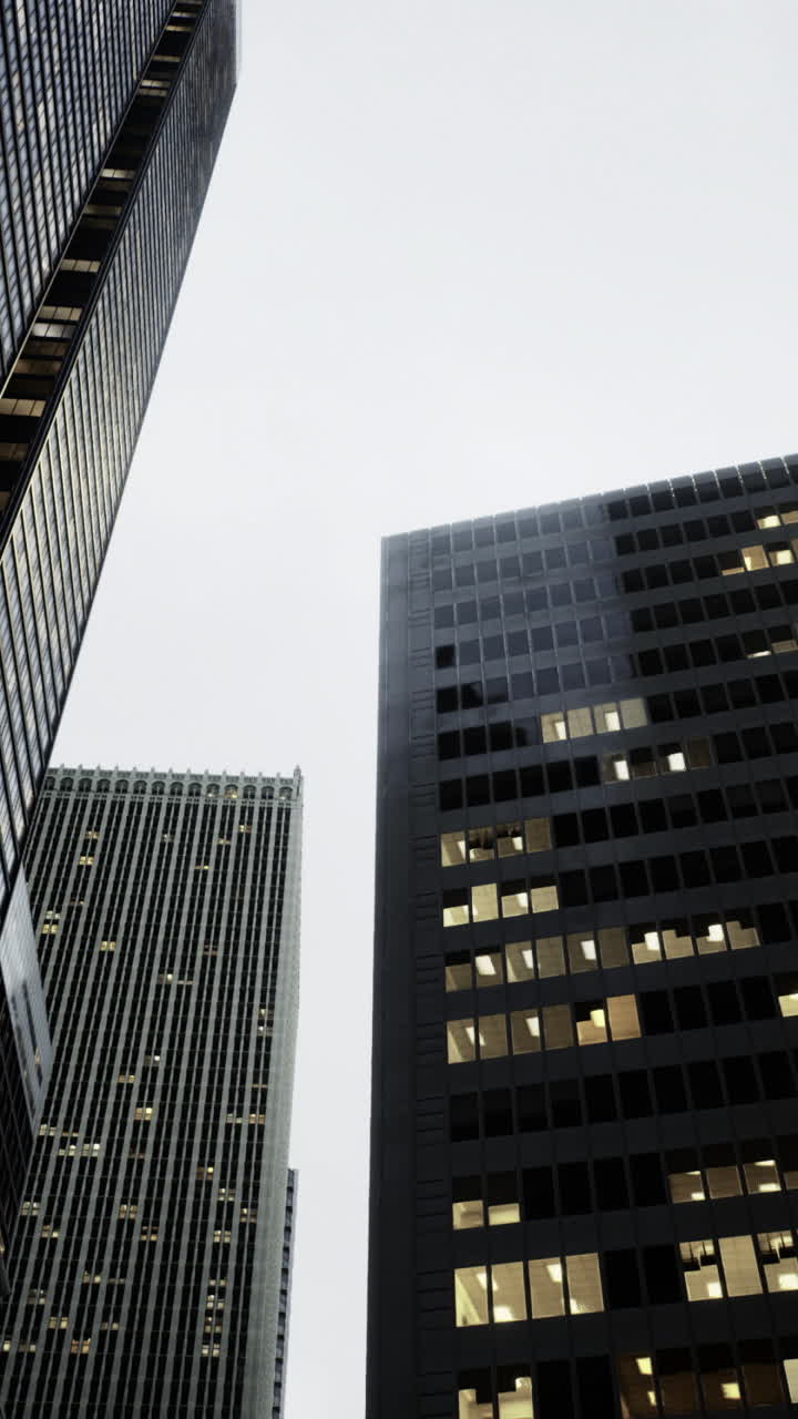 City skyline at dusk with modern skyscrapers and glowing windows