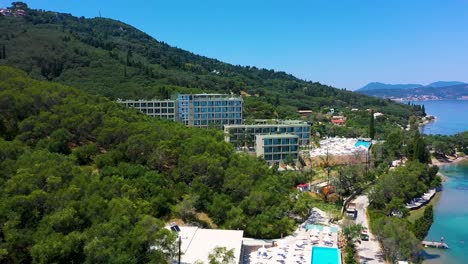 beautiful tracking shot at the coastline of greece, europe, hotels, trees, beach, no people, daylight, a sunny day, blue sky