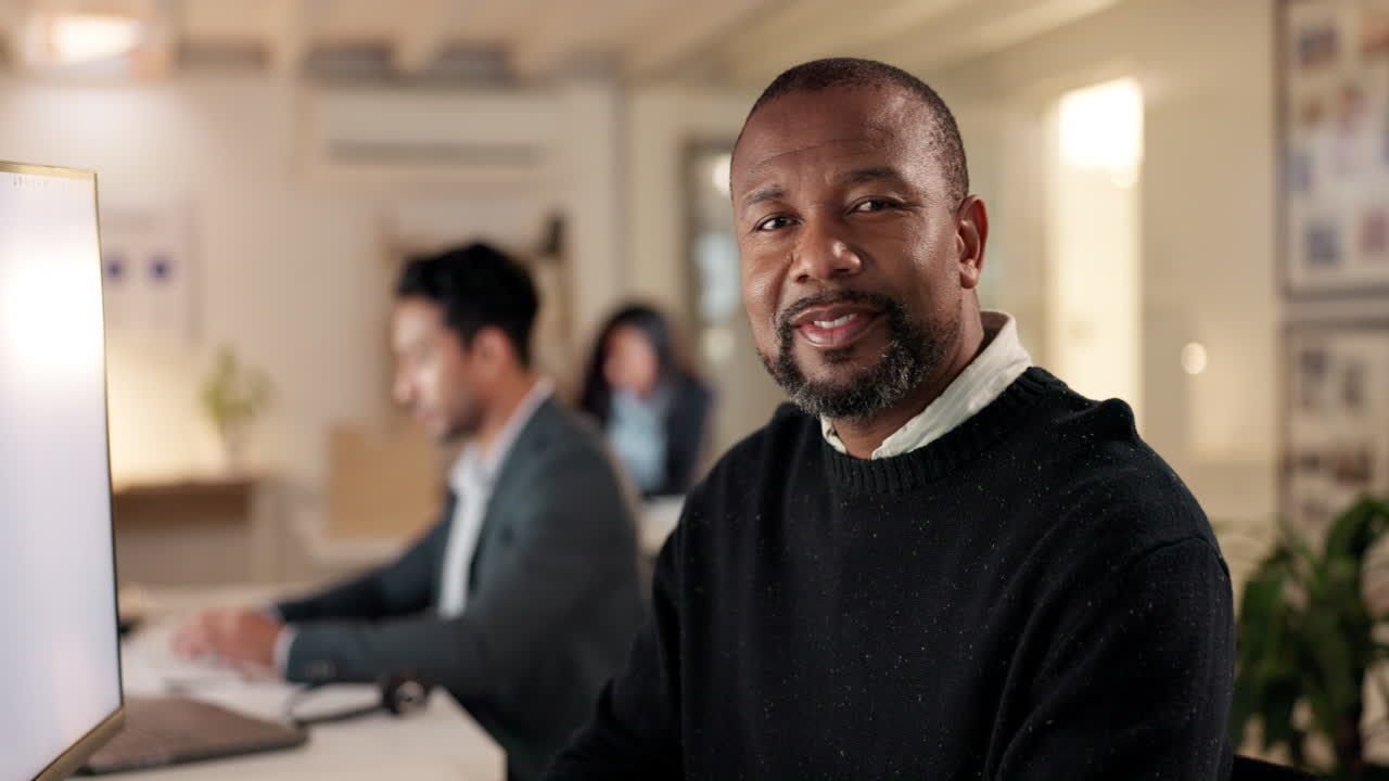 Happy, mature businessman and working on computer