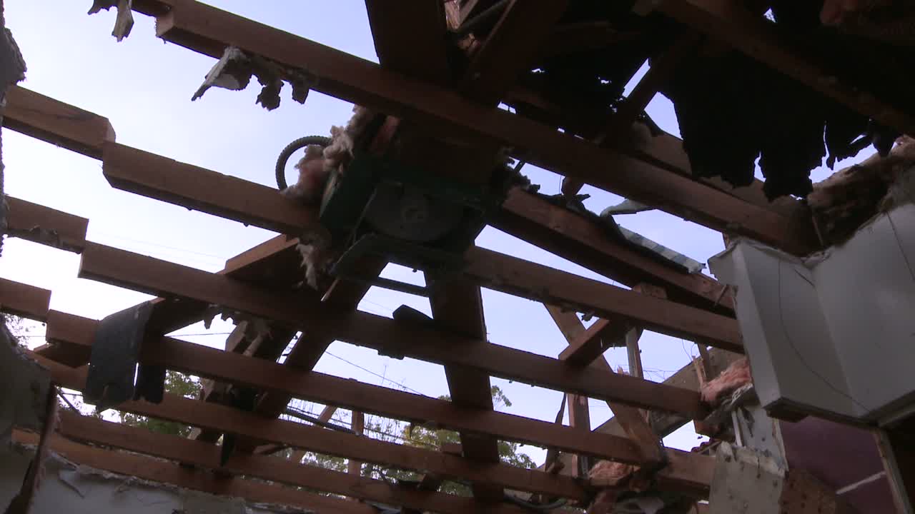 지붕 들보에서 아래로 기울어지고 철거되는 과정에서 집 주변의 패닝 샷