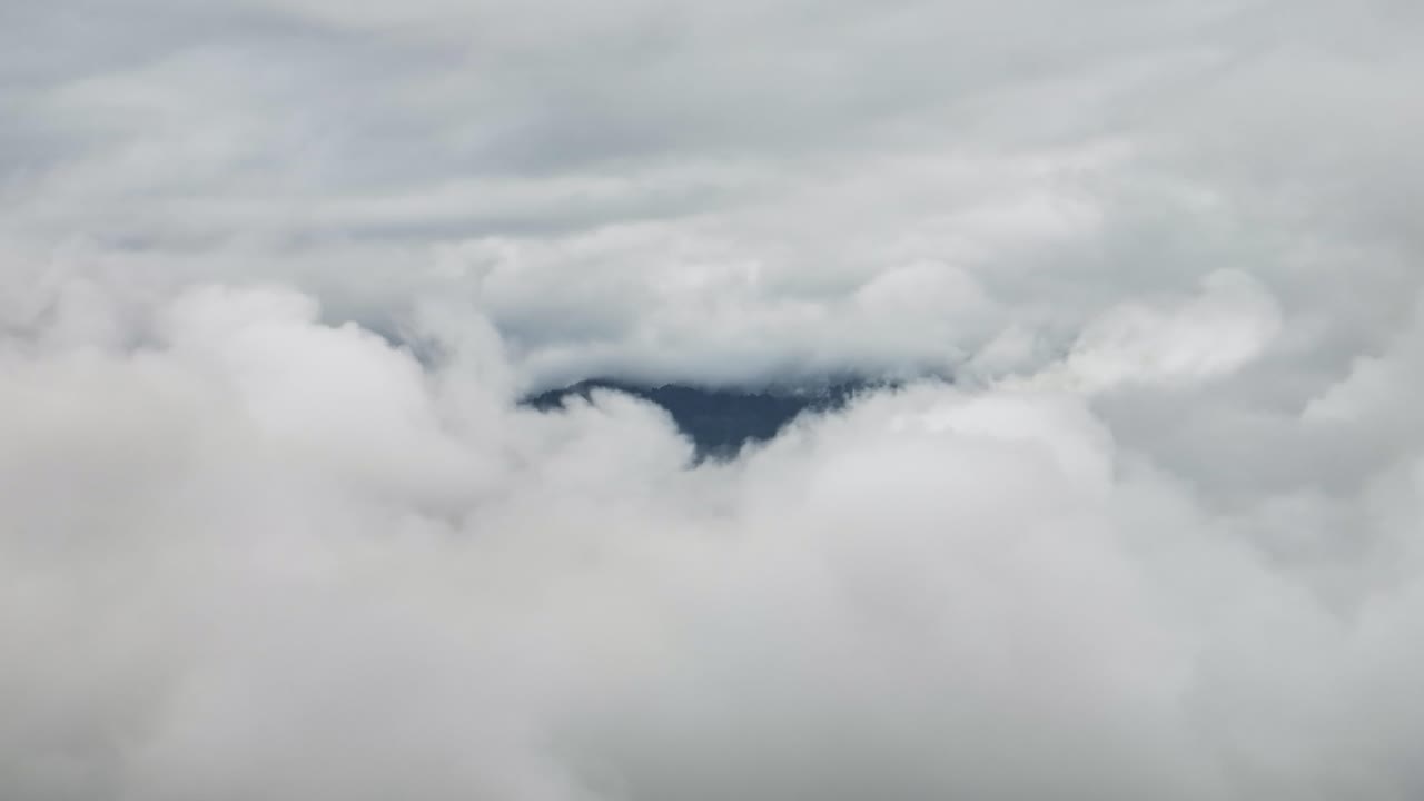 Aerial View of Dense Cloud Cover with a Small Opening in the Sky