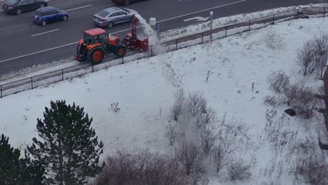 snow blower mounted on tractor clearing the road at winter in mississauga, canada