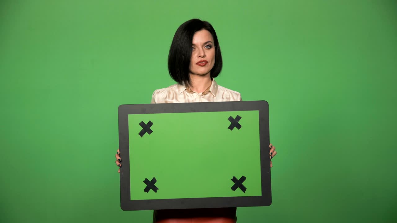 joven hembra sosteniendo una tabla de chromakey