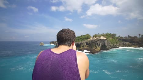 hombre tomando una foto de la costa de bali