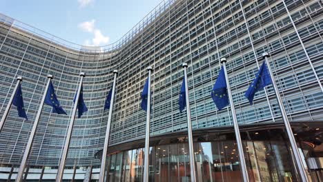 european commission headquarters with eu flags in brussels