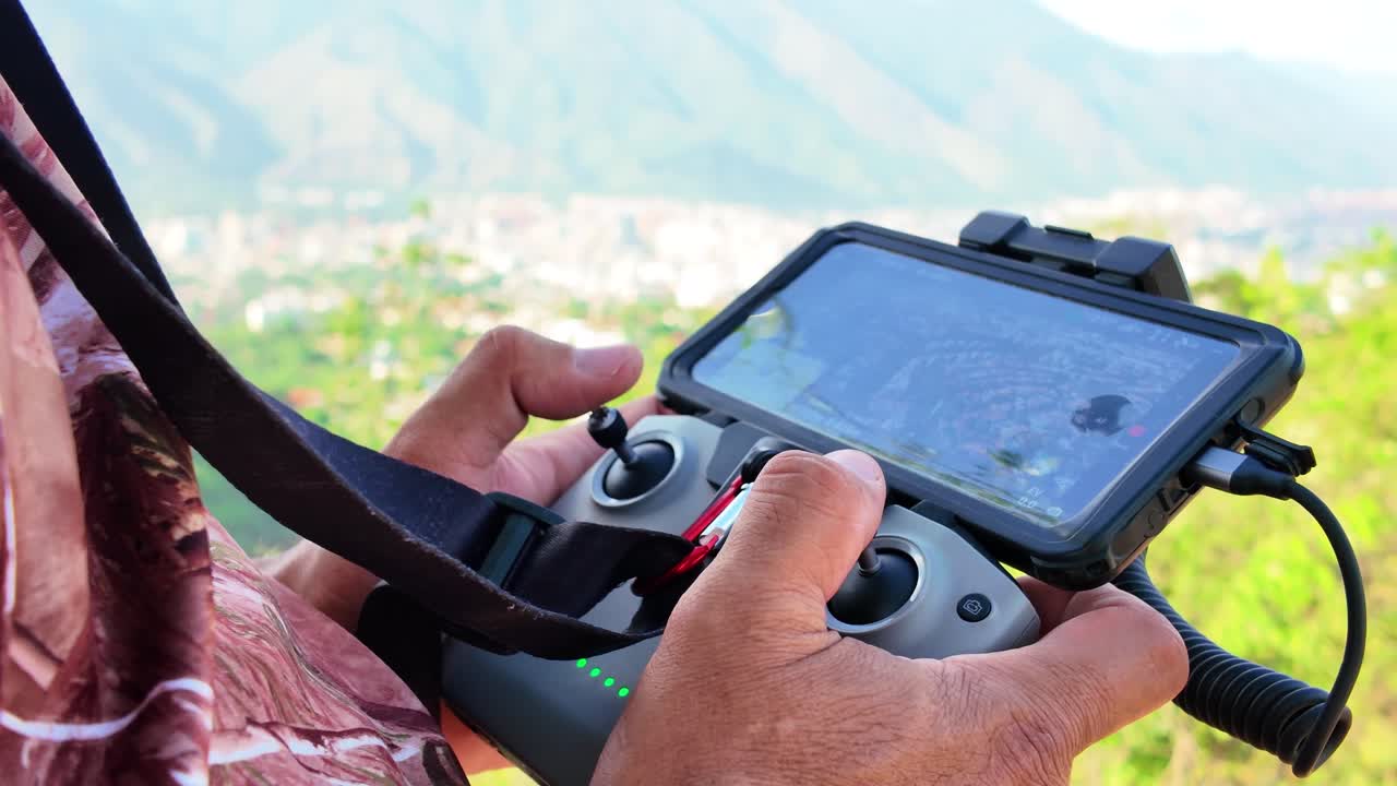 Mobile phone displaying a view from the drone while filming. Tropical scene